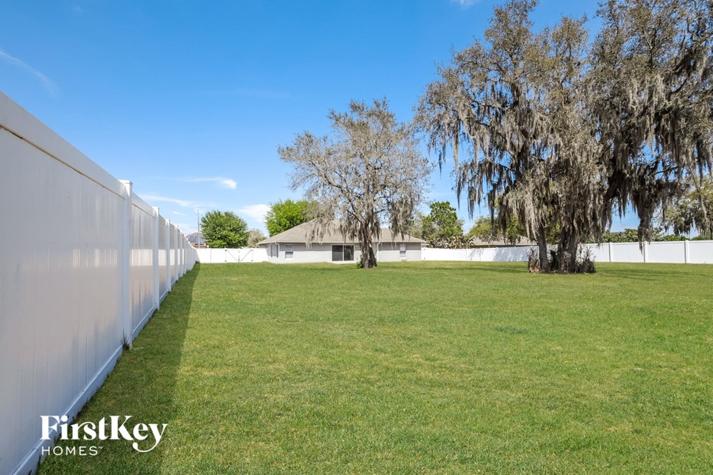 A white fence runs along the edge of a grassy field.