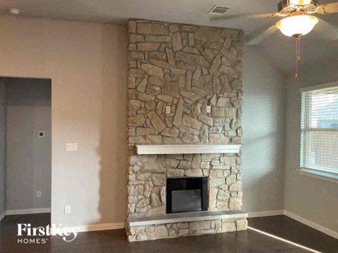 a stone fireplace in the corner of a living room