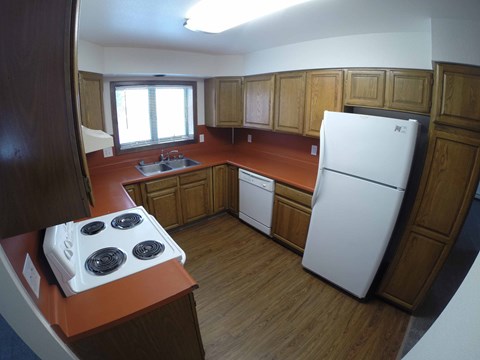 A kitchen with a white fridge and a white stove top.