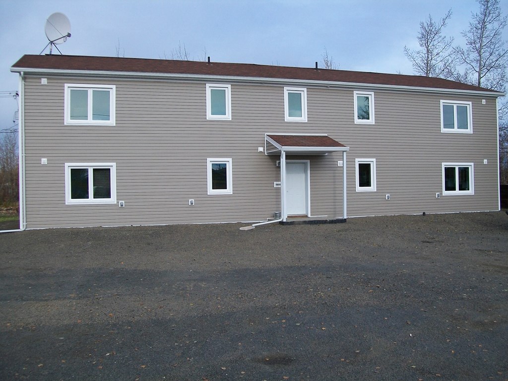 A grey house with a white door and windows.