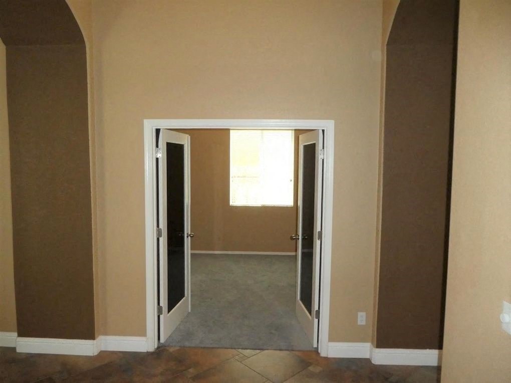 A room with a white door and brown walls.