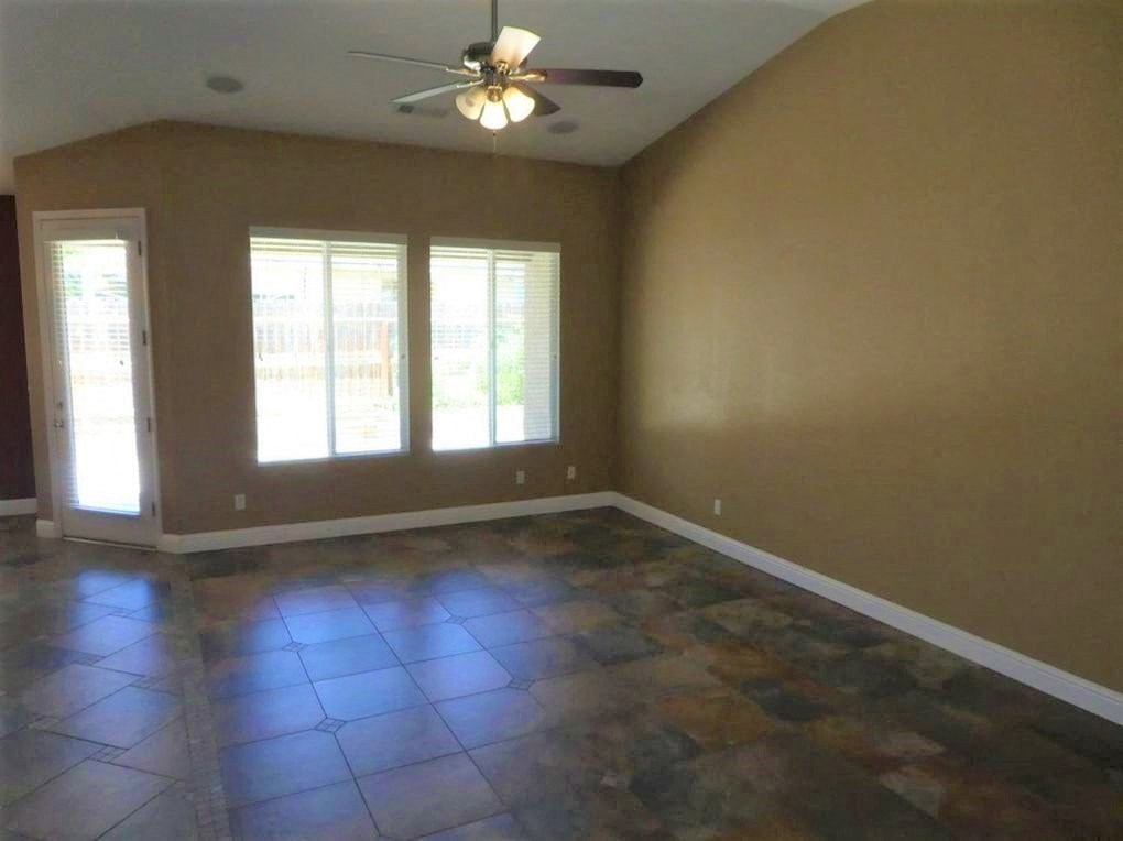 A room with a ceiling fan and tile flooring.