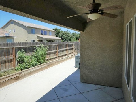 a view of the deck from the living room with a ceiling fan