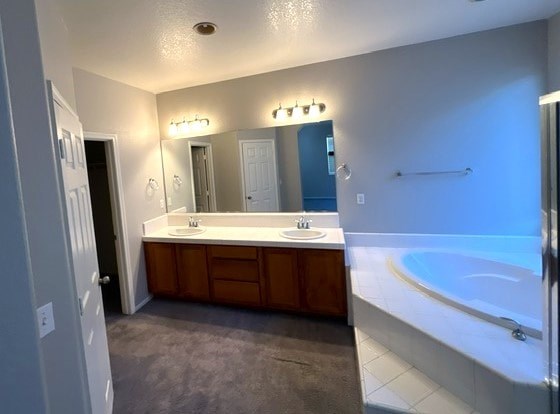A bathroom with a white sink and a white bathtub.
