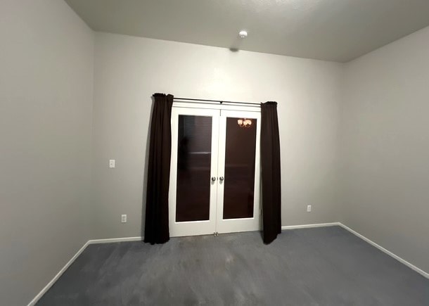 A room with a grey floor and a brown door.