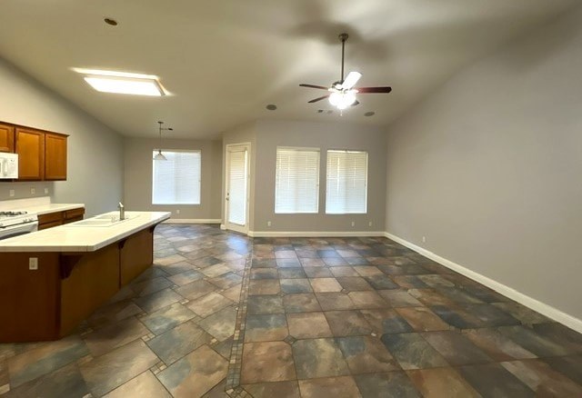 A kitchen with a tile floor and a ceiling fan.