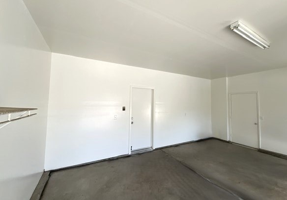 A large empty room with a door and a window.
