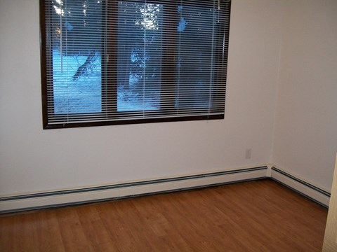 A room with a window and wooden floors.
