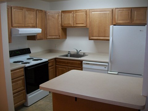 A kitchen with wooden cabinets and a white refrigerator.