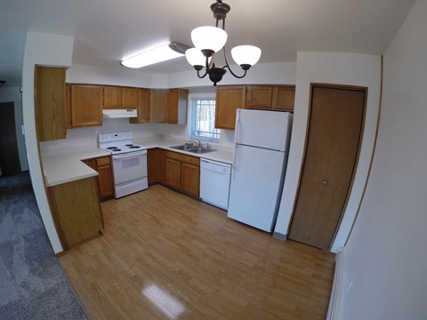 A kitchen with wooden cabinets and white appliances.