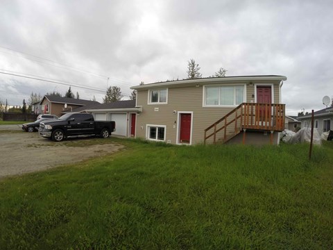 A house with a red door and a brown deck.