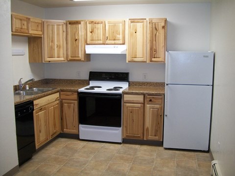 A kitchen with wooden cabinets and a black stove top oven.