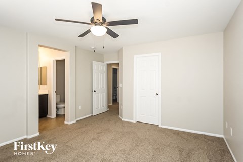 a living room with carpet and a ceiling fan