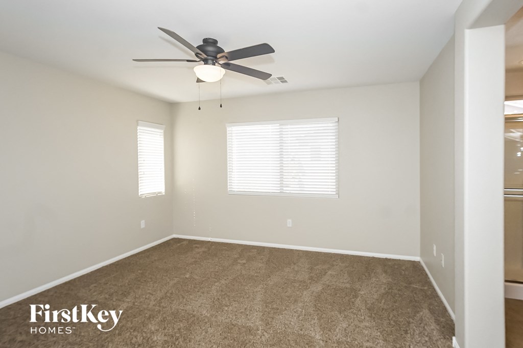 an empty room with a ceiling fan and a window