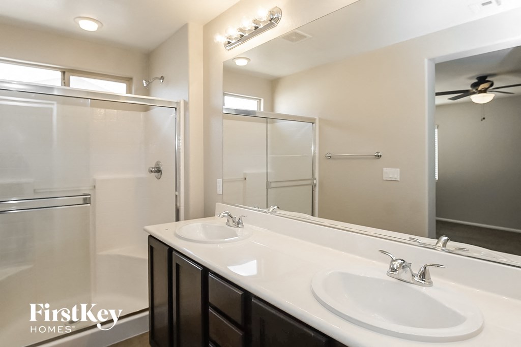 a bathroom with two sinks and a shower and a mirror