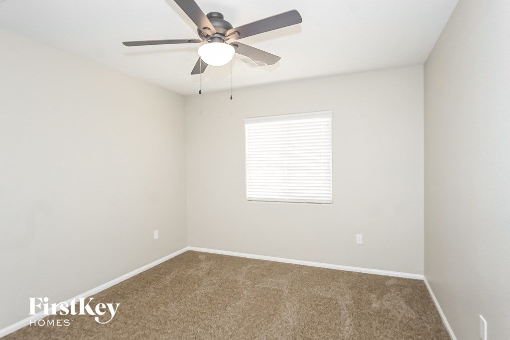a bedroom with a ceiling fan and a window