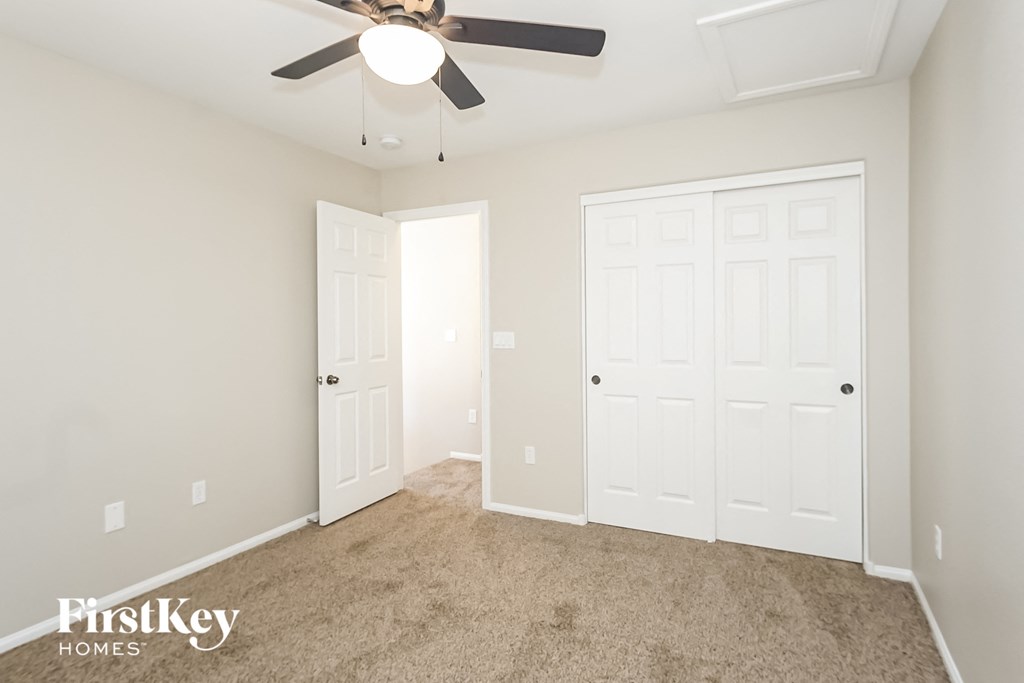 a bedroom with two closet doors and a ceiling fan