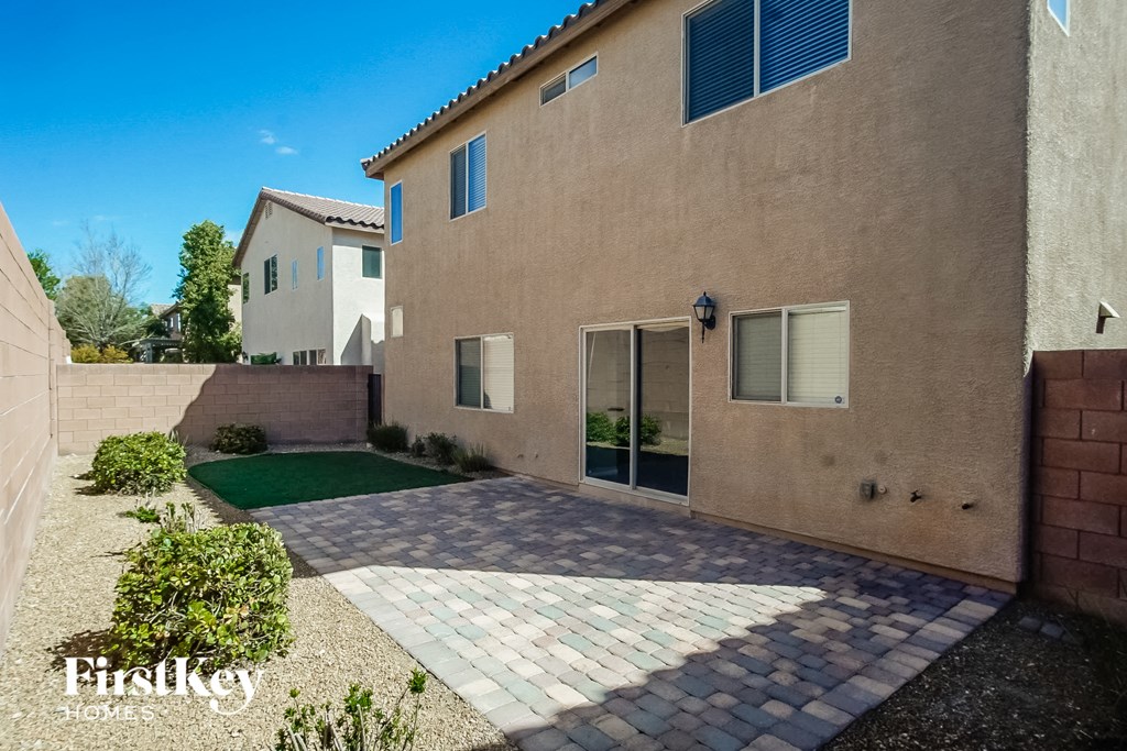 a side view of a tan house with a driveway and lawn
