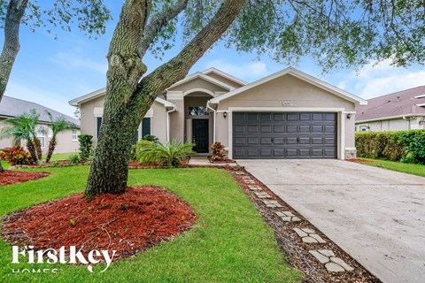 a home with a black garage door and a tree