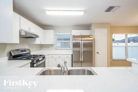a white kitchen with stainless steel appliances and white counter tops