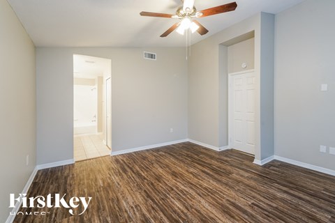 a living room with wood flooring and a ceiling fan