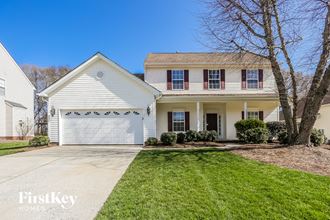 a white house with a white garage door and a green lawn