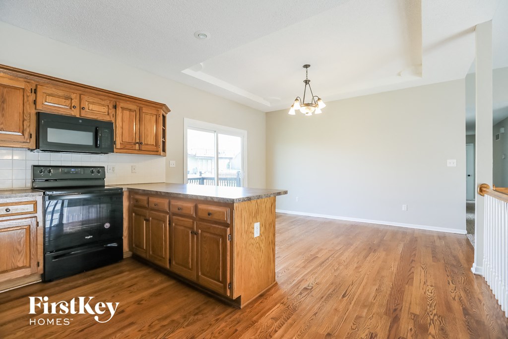 A kitchen with wooden cabinets and a black oven.