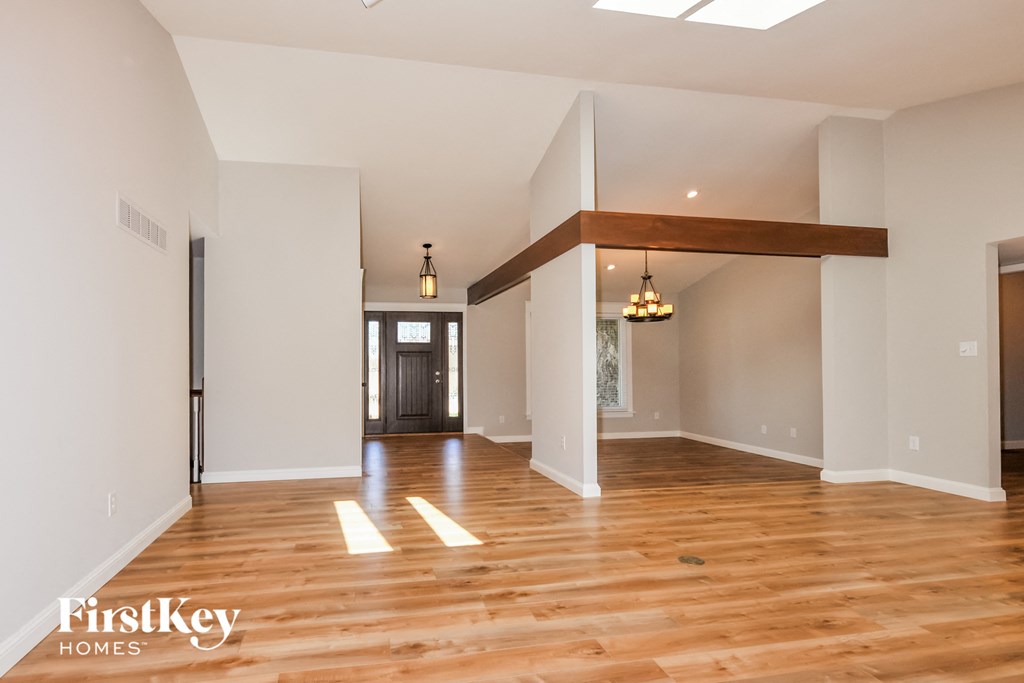 A spacious room with wooden floors and a skylight.