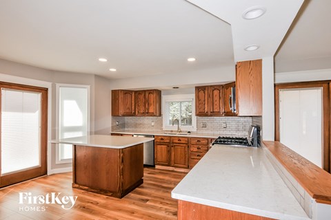 A kitchen with wooden cabinets and a white countertop.