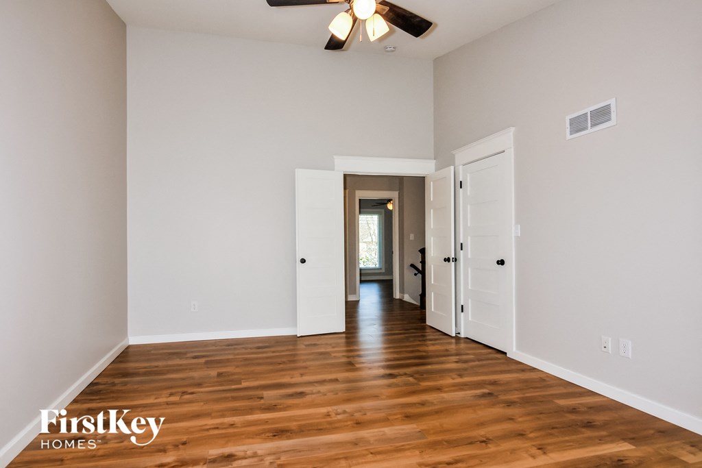 A room with wooden floors and a ceiling fan.
