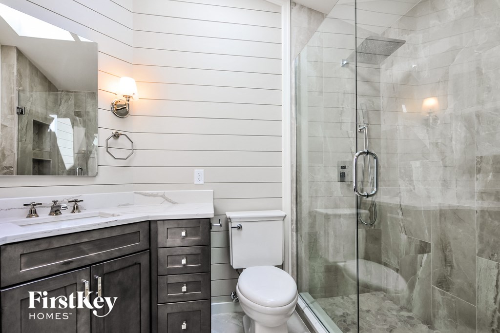 A bathroom with a toilet, sink, and shower.