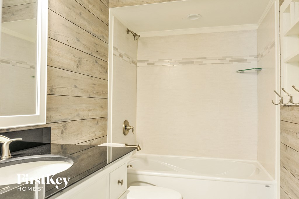 A bathroom with a white tub and a sink.
