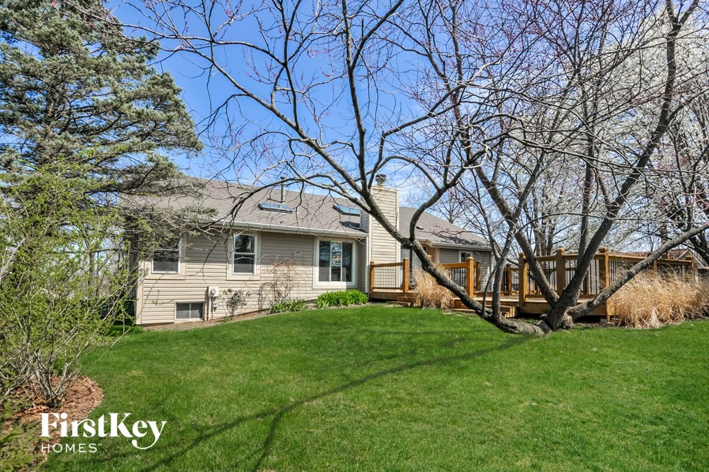 A house with a lawn and a tree in front of it.
