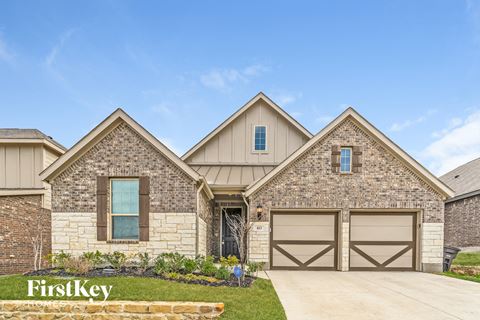 exterior of a home with stone and wood garage doors