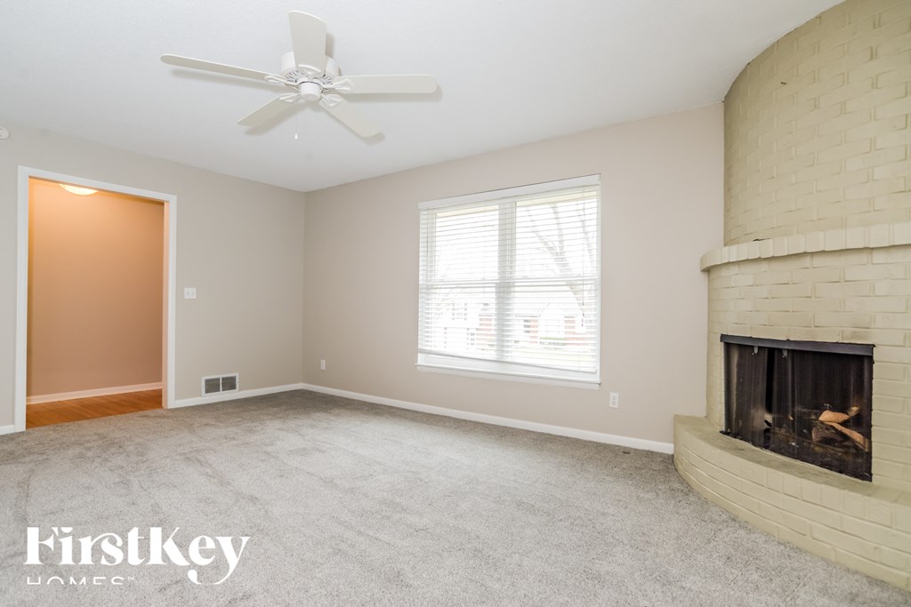 a living room with a fireplace and a ceiling fan