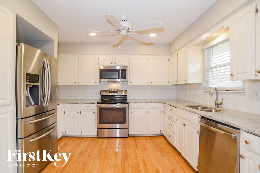 a kitchen with white cabinets and stainless steel appliances