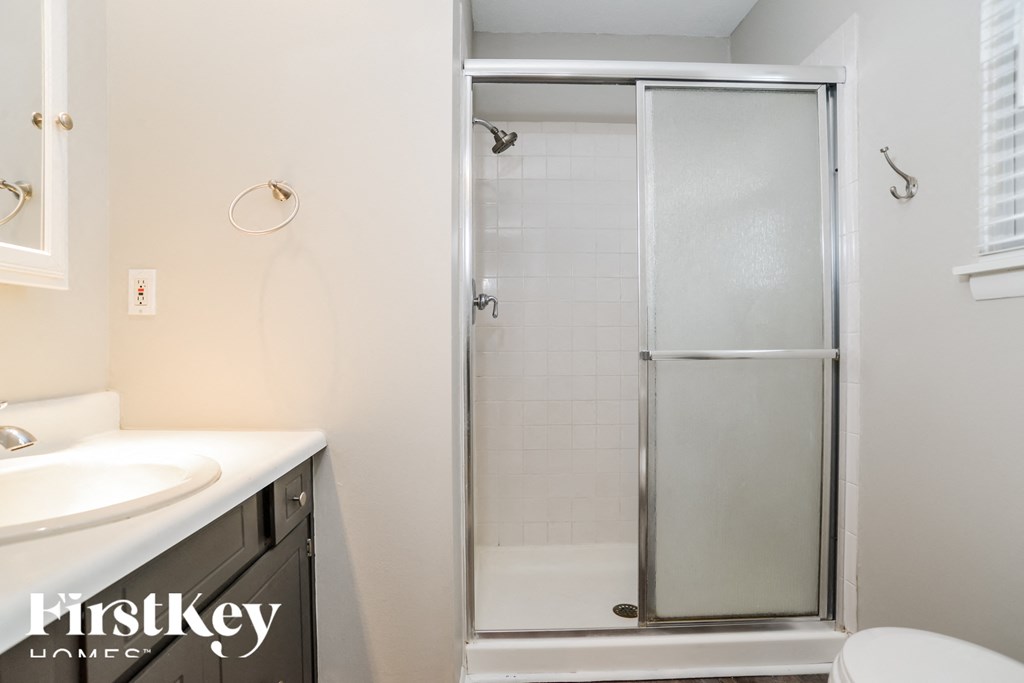 a bathroom with a shower and a sink and a toilet