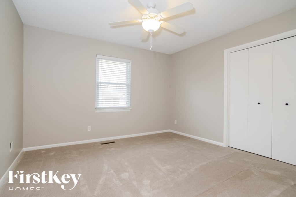 a bedroom with a ceiling fan and a closet