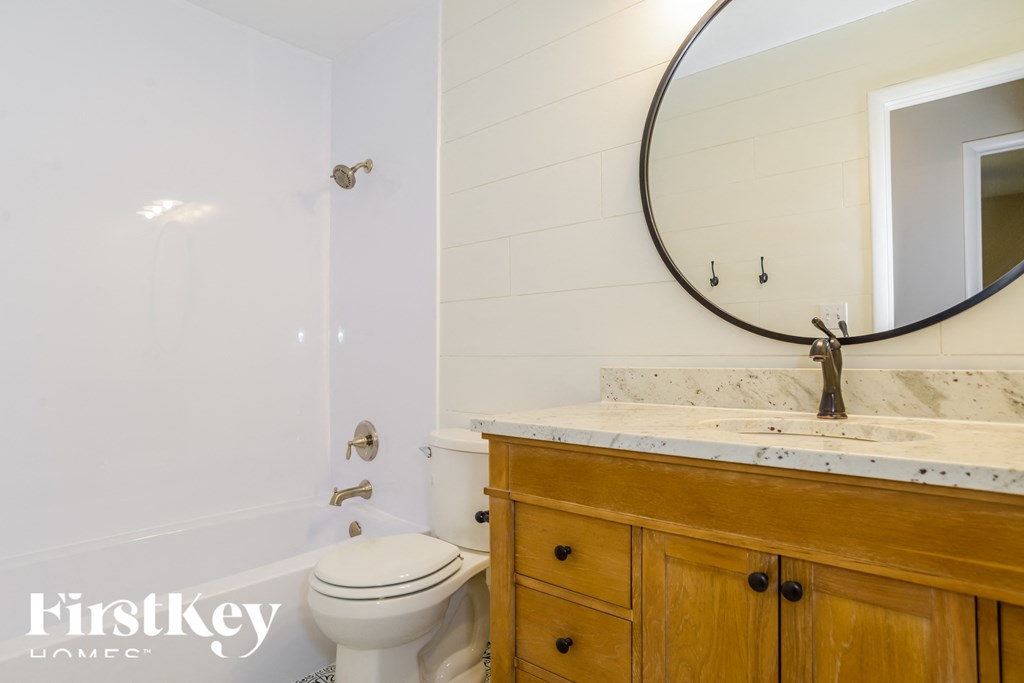 a bathroom with a toilet and a sink and a mirror