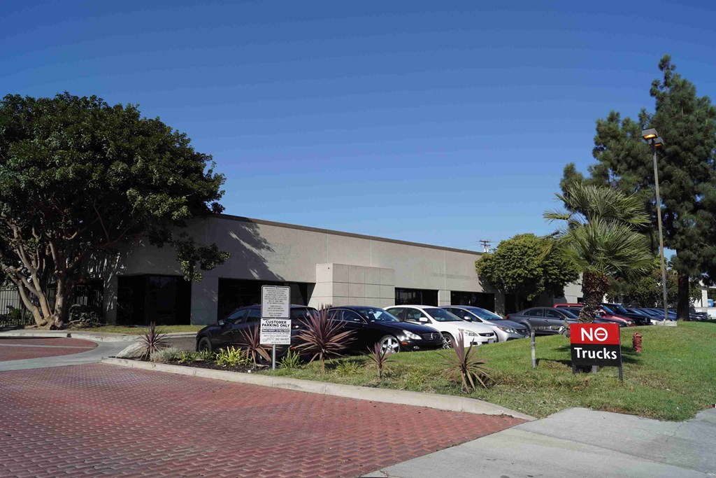 a building with cars parked outside and a no trucks sign