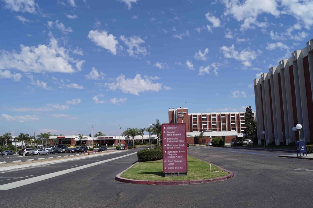 a sign in the middle of an empty street in front of a building
