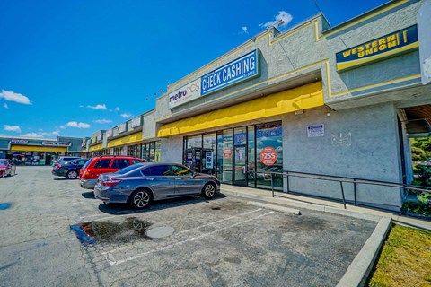 a store with a row of cars parked in front of it