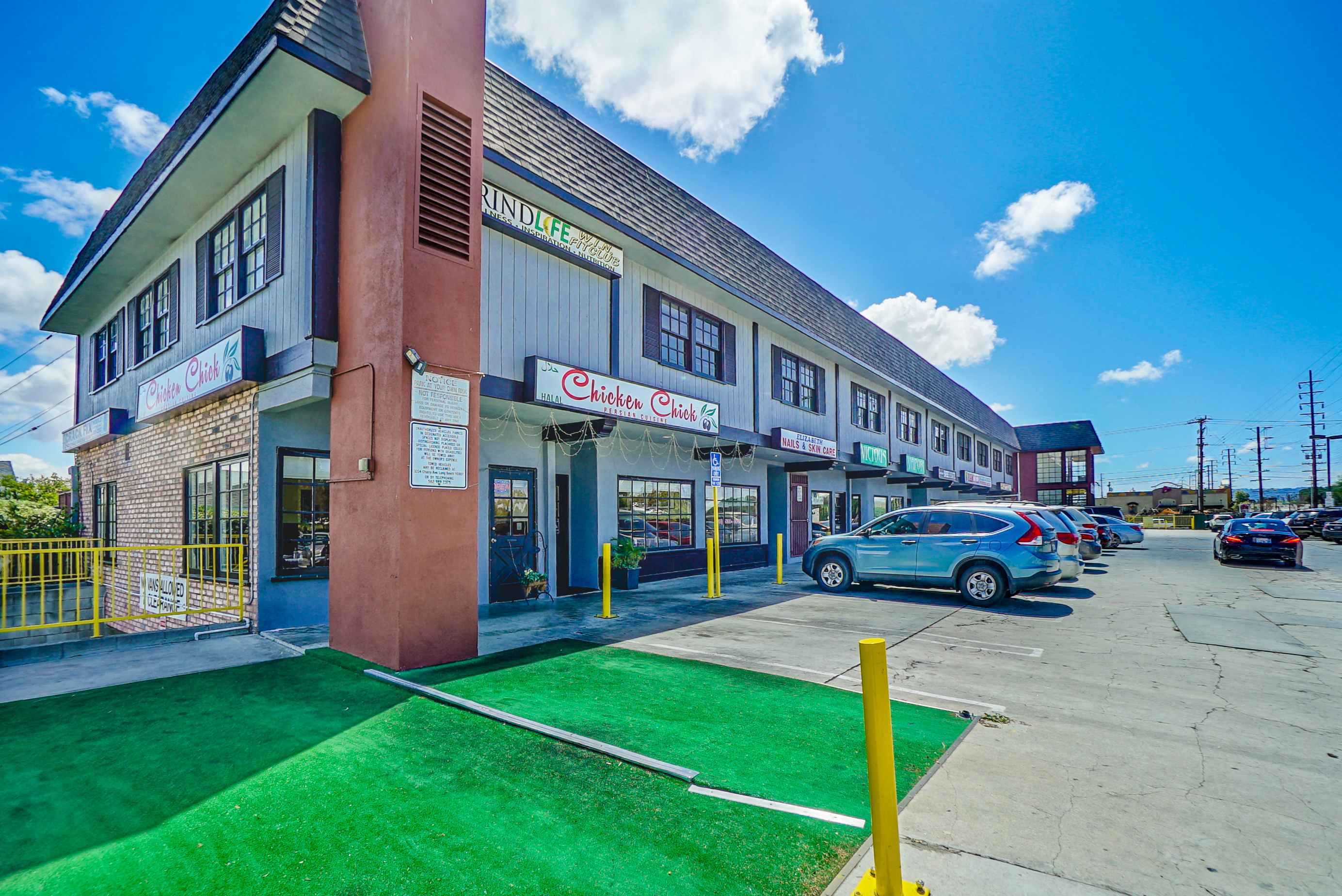 a building with a parking lot and cars parked in front of it