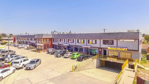 a parking lot in front of a building with cars parked