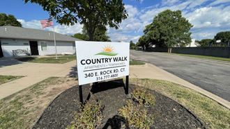 a sign for country walk in front of a house