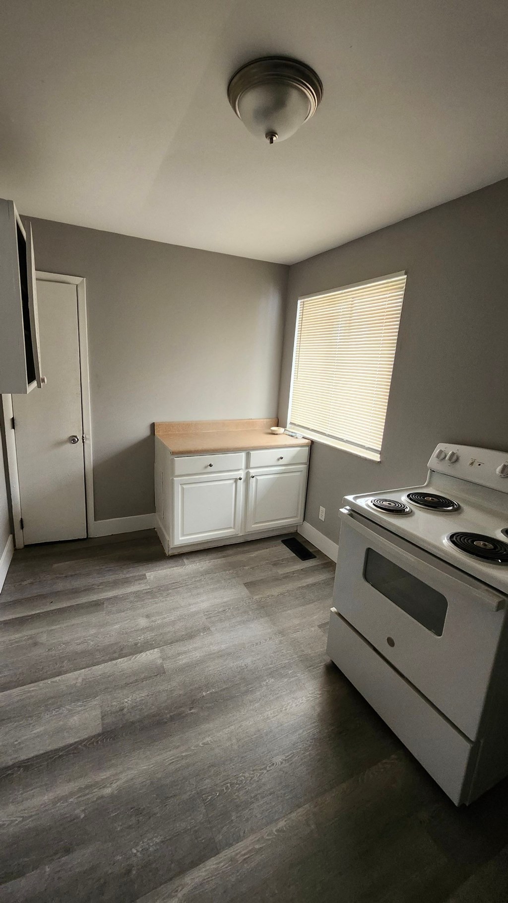 A kitchen with a white stove top oven and a white fridge.