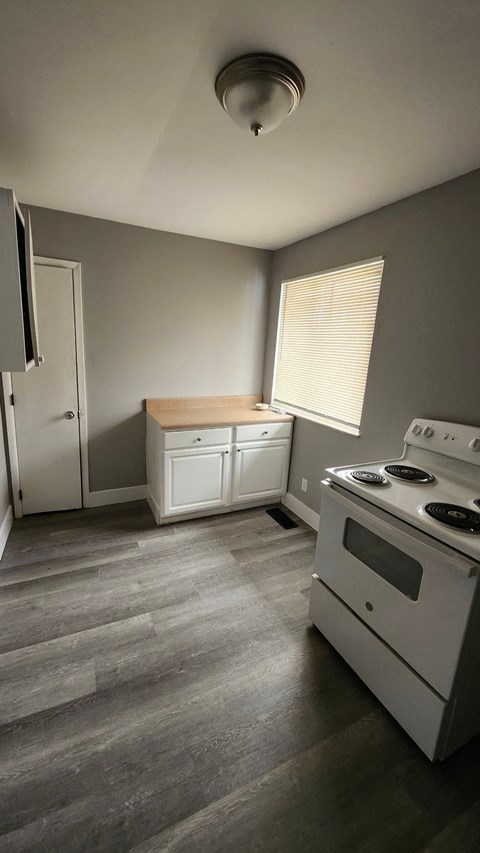 A kitchen with a white stove top oven and a white fridge.