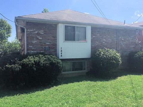 A house with a white door and a brick wall.