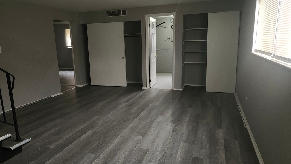 A room with a wooden floor and a white door.