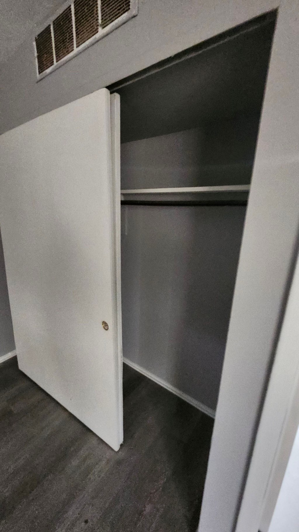 A white door is open to a dark room.